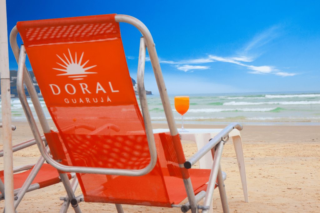 Melhor Hotel do Guarujá a red chair on a beach