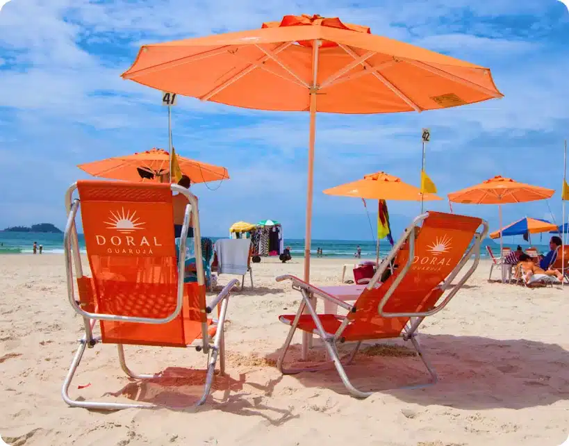 Praia da Enseada - As Comodidades do Hotel Doral Guarujá: Luxo e Conforto chairs and umbrellas on a beach